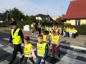umundurowani policjanci wraz z dziećmi na przejściu dla pieszych