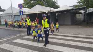 grupa dzieci, pojazdy, przejście dla pieszych, umundurowani policjanci
