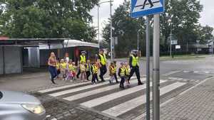 grupa dzieci, pojazdy, przejście dla pieszych, umundurowani policjanci